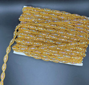 Rhinestone and beaded yardage with golden oval patterns.