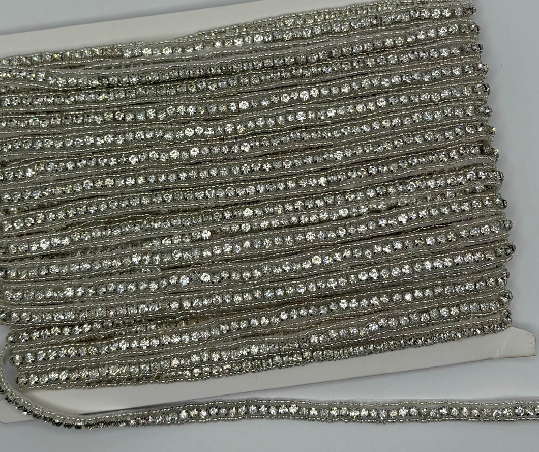 Beaded and rhinestone yardage displayed on a spool.