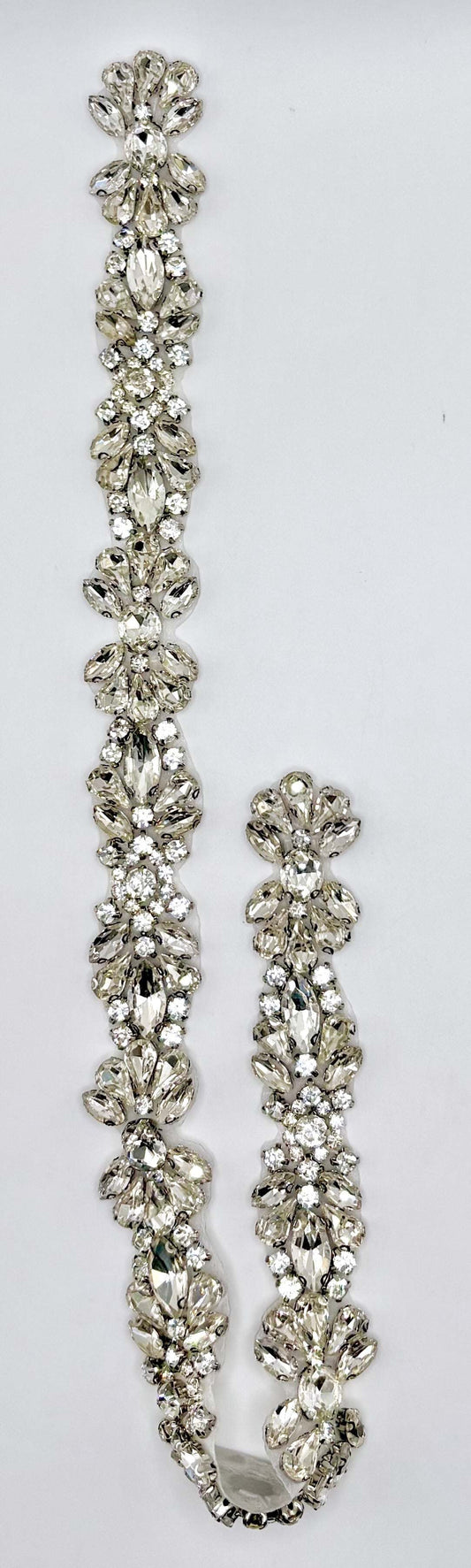 Handmade clear rhinestone bridal belt on silver background.