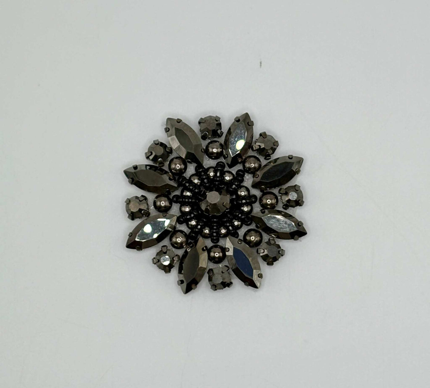 "Olivia Medallion" rhinestone and pearls applique brooch in a round design.